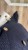 Tweedowa, dwurzędowa marynarka w kolorze granatowym ze złotymi guzikami.